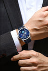 Person wearing luxury watches with  blue face on suit sleeve