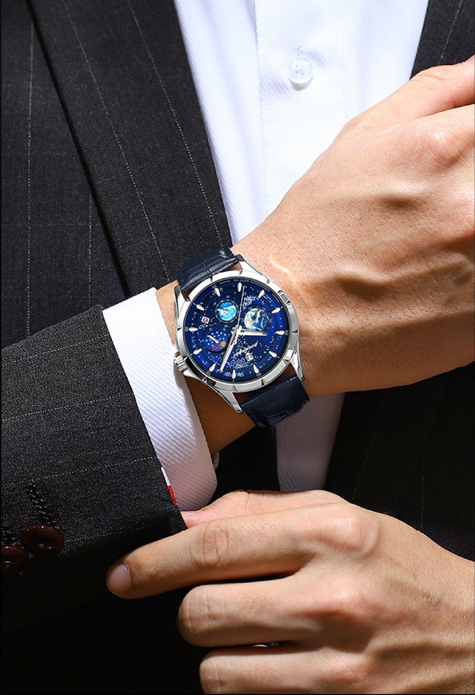 Person wearing luxury watches with  blue face on suit sleeve