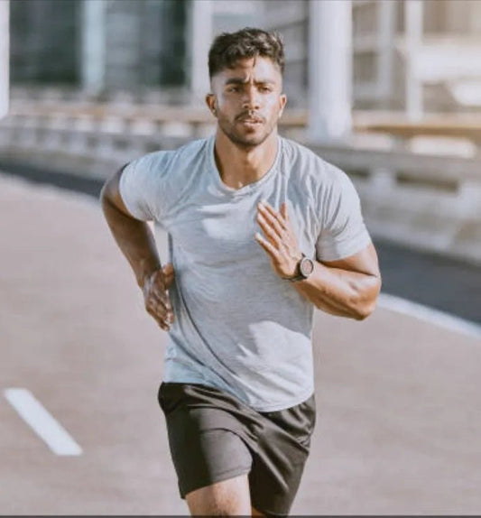 Man running on a road wearing smart watch with a blurred background UK