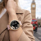 Smartwatch womens with pink strap worn on wrist, with blurred background of UK.