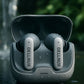 Delinux wireless earbuds with charging case on reflective surface with water droplets.